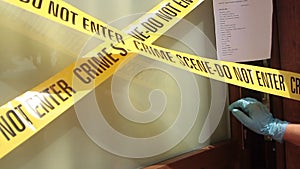 Door of a house taped with crime scene tape and the paper that subjects it to judicial seizure that is forcibly abolished by the