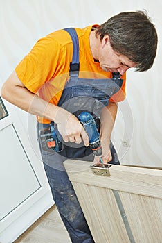 Door. installation. Carpenter works with drill