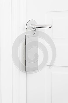 Door knob with empty label on a door handle for your text. Empty white flyer mockup hang on door handle. Leaflet design