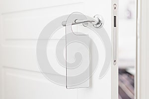 Door knob with empty label on a door handle for your text. Empty white flyer mockup hang on door handle. Leaflet design photo