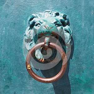A door knocker is a fixture on the front door of a house. It is made of metal and has the form of a ring, which is