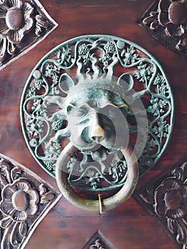 A door knocker is a fixture on the front door of a house. It is made of metal and has the form of a ring, which is
