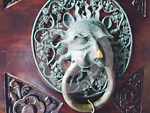 A door knocker is a fixture on the front door of a house. It is made of metal and has the form of a ring, which is