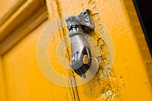 Door knocker knob closeup hand shape old vintage yellow orange