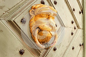Door knocker in the shape of a golden lion
