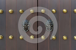 The door and knockers of Chinese temple. Ancient Asian door from temple. Chinese door. Oriental design of door of palace hall in F