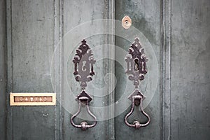 Door knockers, lock and a mailbox of an ancient green wooden door