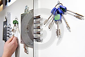 Door lock and keys in store on white wall photo