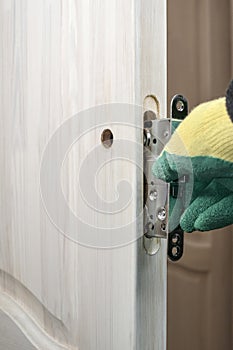 Door lock repair and replacement. Installation and insertion lock in a wooden door