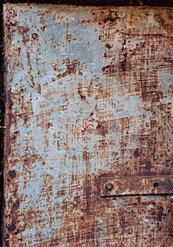 Door made rusty shabby sheet metal, brown rust, scratched peeled off blue paint, textured rough metal surface, rusty metal