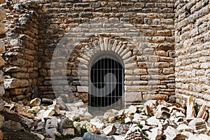 The door is from the metal grille of an ancient antique building, a castle of stone with sprawling blocks