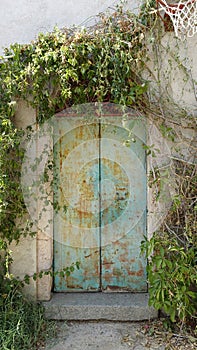 The door with metal swings of an ancient house in the countryside.