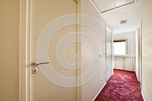 a door open to a hallway with a red carpet