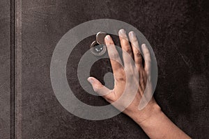 Door peephole and hand. peephole close-up.