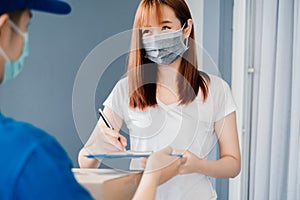 Door to door delivery express sending send a package wearing mask to customer receiver sign