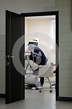 Through the door is a video of a dentist treating a patient`s teeth.