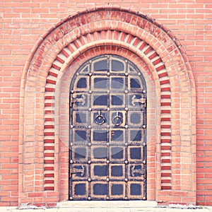 The door of a vintage church in the Old Russian style in a red brick wall