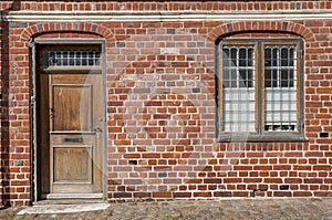 Door and window on red brick wall