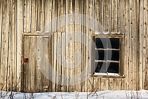 Door and window on wall of an old wooden barn