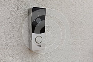 Doorbell on the wall of the house with a surveillance camera photo