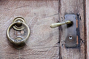 Doorknob and knocker on old wooden door photo