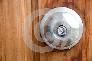 Doorknob silver stick blacked beautiful brown wooden door.