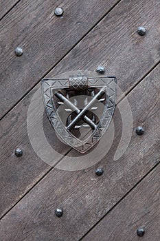 Doorknocker on the wooden gate fixed with rivets