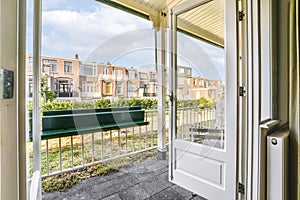 doors open to a balcony with a view of houses