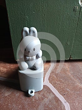 doorstop in the shape of a cute blue rabbit on the tile floor