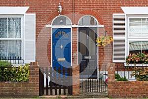 The doorway or entrance to typical Victorian terraced housing showing the front gate and windows with shutters