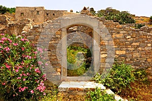 Doorway to ruins with wildflowers, Spinalonga Island, Crete, Greece