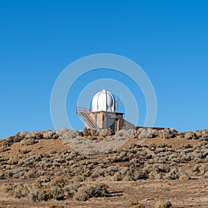 Doppler radar station in the desert against a clear blue sky with copy space