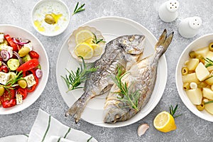 Dorada fish sea bream baked, fresh vegetable greek salad, boiled potatoes with garlic and olives and tzatziki dip. Healthy food