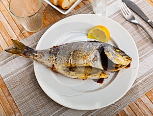 Dorada fish served on plate with lemon