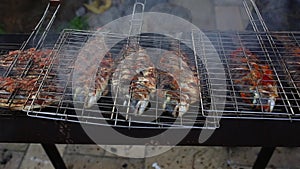 Dorado fish grilled over charcoal. cooking seafish with aromatic spices on barbecue grill plate.