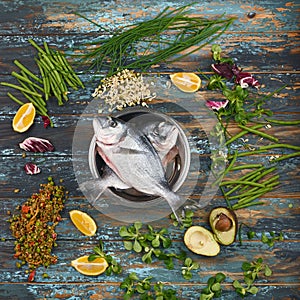 Dorado and natural ingredients for healthy food on rough dyed wooden background.