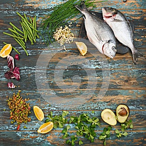 Dorado and natural raw ingredients for for healthy food on rough dyed wooden background.