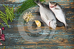 Dorado and natural raw ingredients for healthy food on rough dyed wooden background.