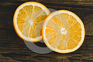 Dorange slices on an orange wooden background. Top view