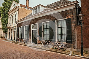 Facade of elegant brick buildings and bicycles on the street in a cloudy day at Dordrecht.