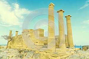 Doric temple of Athena Lindia on Acropolis of Lindos Rhodes, Greece. Front view of columns and walls. near tree grows