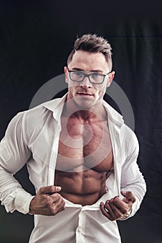 Dorky man with glasses and muscle chest under shirt photo