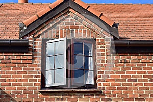 Dormer window of red brick cottage