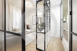 Bedroom with double bed with black shelves, mirrors and sink photo