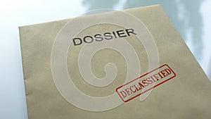 Dossier declassified, seal stamped on folder with important documents, close up photo