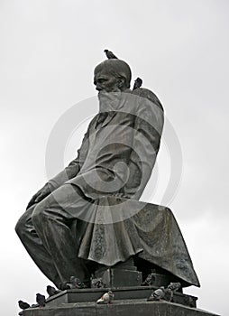 Dostoevsky monument in Moscow with a dove on his head and grey sky