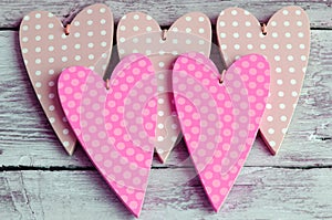 Dotted pale green hearts on wooden background