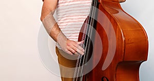 Double bass player man playing classic wooden violoncello or contrabass on white background,