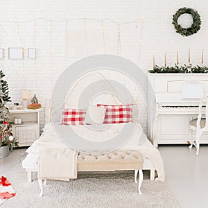 Double bed in the bedroom decorated for Christmas in red and white colors