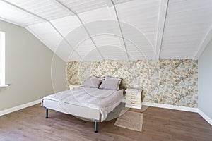 Double bed in interior of the modern bedroom in loft flat in light color style of expensive apartments